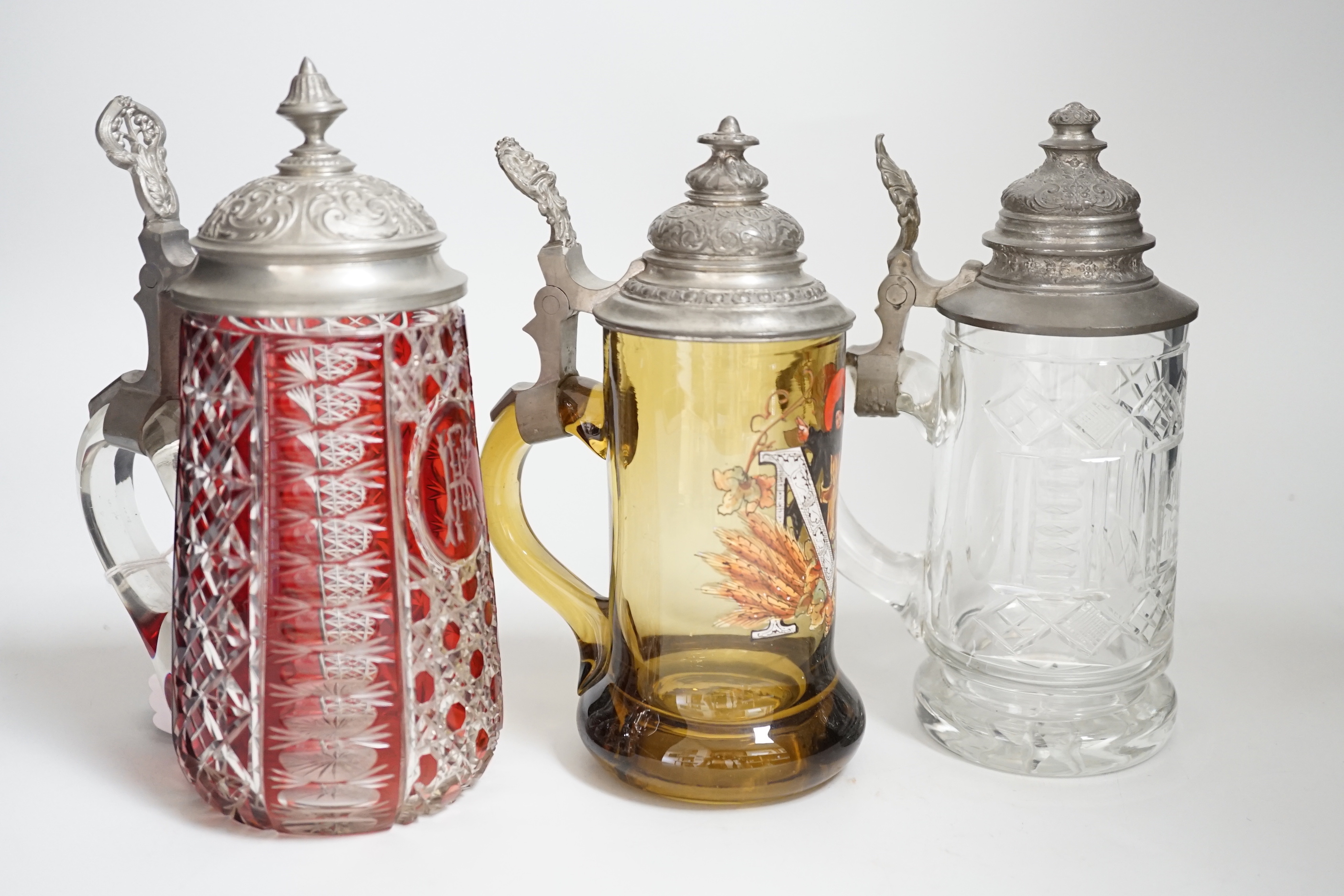 Three German glass steins including a Bohemian ruby flashed example, the largest 20cm high